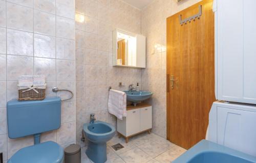 a bathroom with a blue toilet and a sink at Apartman Mikulić Makarska in Makarska