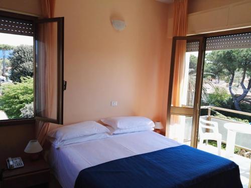 een slaapkamer met een bed en een groot raam bij Hotel Elizabeth in Marina di Pietrasanta