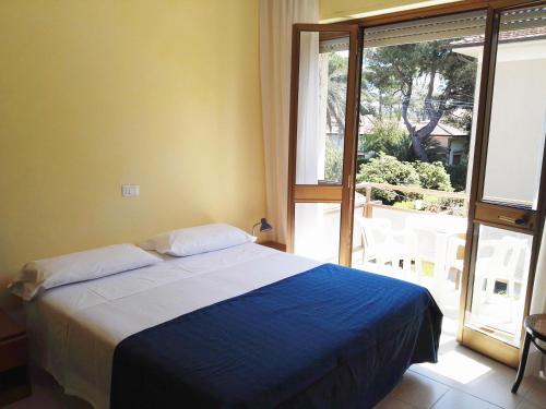 a bedroom with a bed and a large window at Hotel Elizabeth in Marina di Pietrasanta