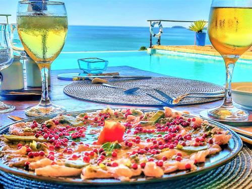 a table with a plate of food and glasses of wine at Le Grand Bleu in Andilana