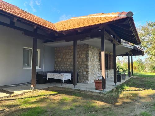 un patio avec un banc sous un toit dans l'établissement Zelena oaza - kuca za odmor, à Golubac