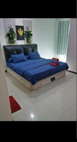 a bedroom with a bed with blue sheets and blue pillows at 2 BR Jungle Decor Beautiful Sea View Fast Internet Top Of The Mall in Jakarta