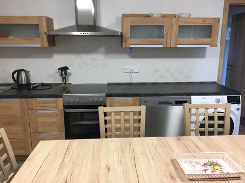 a kitchen with a wooden table and a counter top at Penzion u Laštůvků in Šluknov