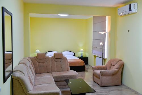 Imereti Health Resort في تسكالتوبو: غرفة معيشة مع أريكة وسرير