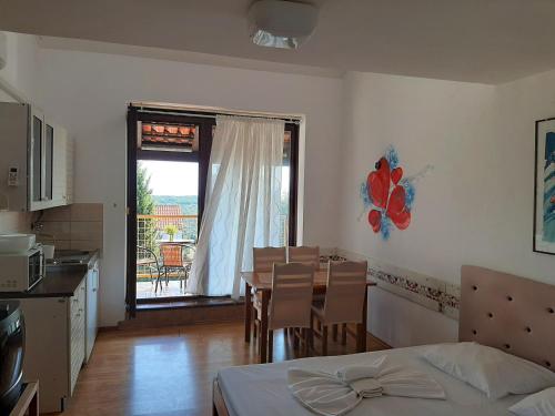 a bedroom with a bed and a table and a kitchen at Apartments Unija Duga Uvala in Krnica