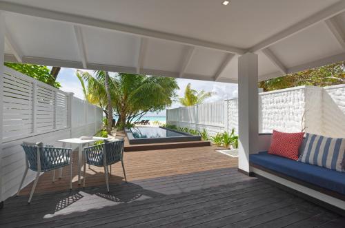 a patio with a table and chairs on a deck at Villa Nautica Paradise Island Resort in North Male Atoll
