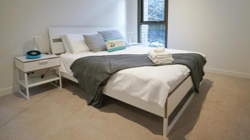 a bedroom with two beds and a nightstand and a bed sidx sidx sidx sidx at SYDNEY CBD WALK TO DARLING HARBOUR MODERN 1 BED APT NSY188 in Sydney