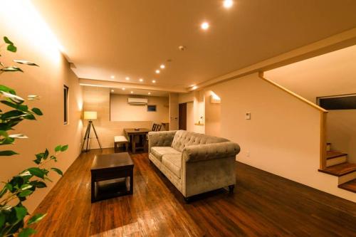 a living room with a couch and a table at D-and Stay HH.Y Resort Okinawa in Teruya