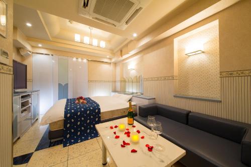 a room with a bed and a table with fruit on it at HOTEL THE i Adult only in Higashi-osaka