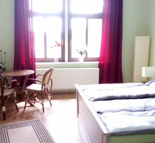 1 dormitorio con 2 camas, mesa y ventana en Ferienwohnung Erzgebirge en Geyer