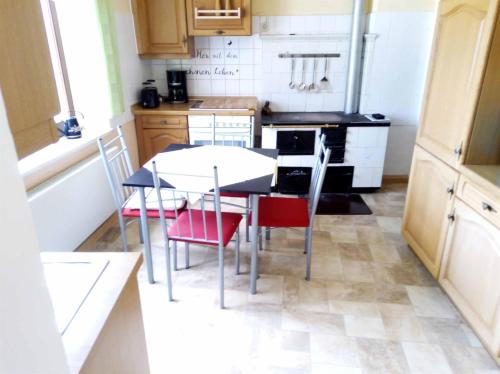 a small kitchen with a table and chairs in it at Ferienwohnung Erzgebirge in Geyer