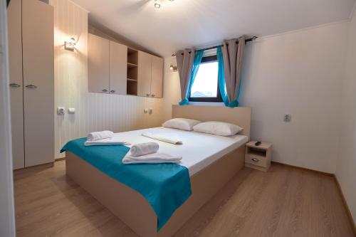 a bedroom with a bed with two towels on it at Stanford Apartments Gara de Nord in Bucharest