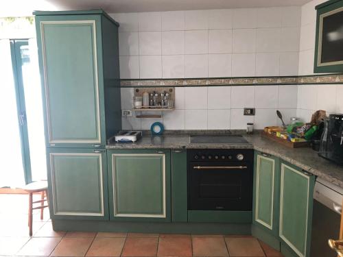 a kitchen with green cabinets and a black oven at El Olivo de Sansol in Sansol