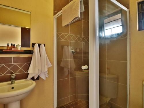 a bathroom with a shower and a sink at Timeless Lodge in Umkomaas