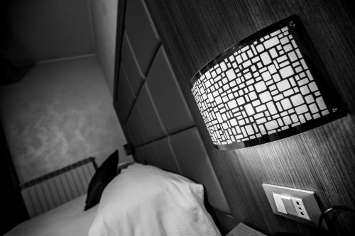 a bed with a lamp on top of it at Hotel La Compagnia Del Viaggiatore in LʼAquila