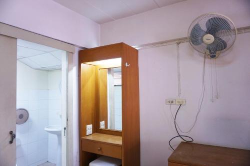 uma casa de banho com uma ventoinha na parede e um lavatório. em Water Well Guest House em Chiang Mai