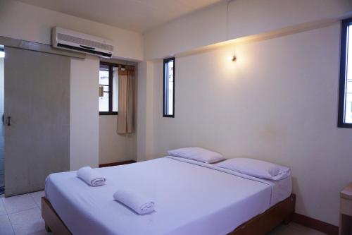 um quarto com uma grande cama branca com dois travesseiros em Water Well Guest House em Chiang Mai