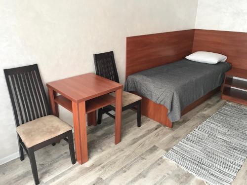a bedroom with a bed and a table and chair at готель Вікторія in Volovets