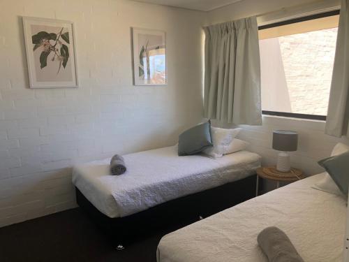 a bedroom with two twin beds and a window at Apt 56 Riverview Holiday Apartments in Kalbarri