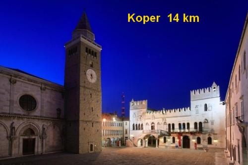 a large building with a clock tower at night at Floating House Sea Queen in Portorož