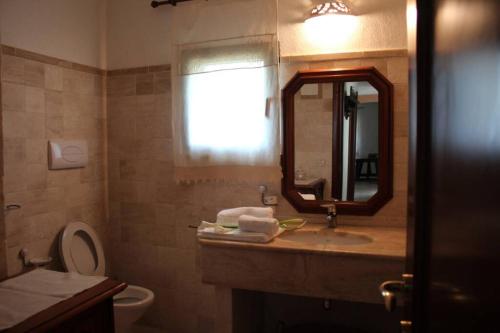 y baño con lavabo, aseo y espejo. en Villa di campagna vicino al mare, en Orosei