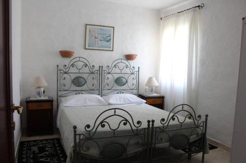 1 dormitorio con 1 cama, 2 lámparas y ventana en Villa di campagna vicino al mare, en Orosei