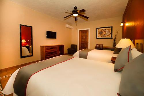 a bedroom with two beds and a ceiling fan at La Casona Tequisquiapan Hotel & Spa in Tequisquiapan