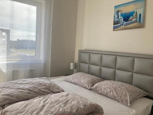 ein Bett mit zwei Kissen in einem Schlafzimmer mit einem Fenster in der Unterkunft Luksusowy Apartament in Ostrowo