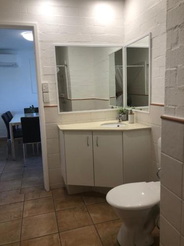 La salle de bains est pourvue de toilettes, d'un lavabo et d'un miroir. dans l'établissement Apt 56 Riverview Holiday Apartments, à Kalbarri