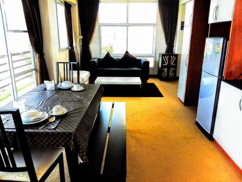 a living room with a table and a couch at โรงแรม ชาโตว์วิสต้า in Chon Buri