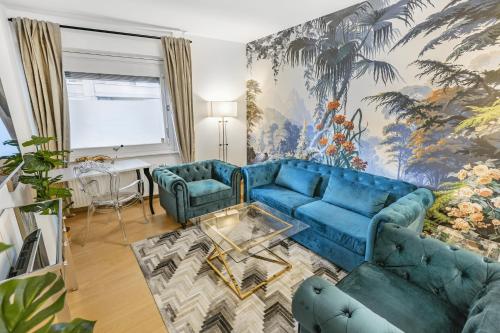 a living room with a blue couch and two chairs at Oasis 2 bedroom apartment in Montreux centre in Montreux
