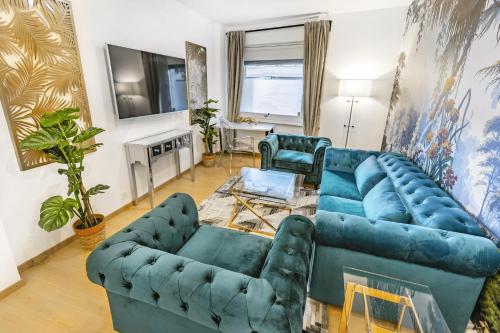 a living room with two blue couches and a television at Oasis 2 bedroom apartment in Montreux centre in Montreux