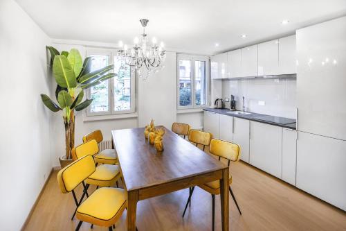 a kitchen with a dining room table and yellow chairs at Oasis 2 bedroom apartment in Montreux centre in Montreux