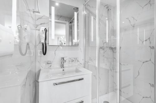 a white bathroom with a sink and a shower at Oasis 2 bedroom apartment in Montreux centre in Montreux
