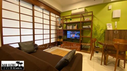 a living room with a couch and a tv at Sea View & Pool View & WiFi & Netflix at Iman Kazoku TimurBay Ville Studio 2BDR in Kuantan