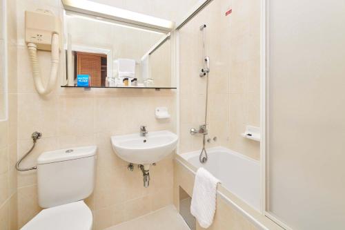 a bathroom with a toilet and a sink and a shower at Apartments Bellevue Plava Laguna in Poreč