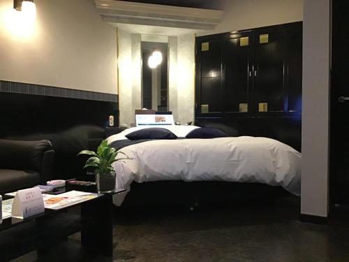 a bedroom with a bed and a couch and a table at Valentine (Adult Only) in Tottori