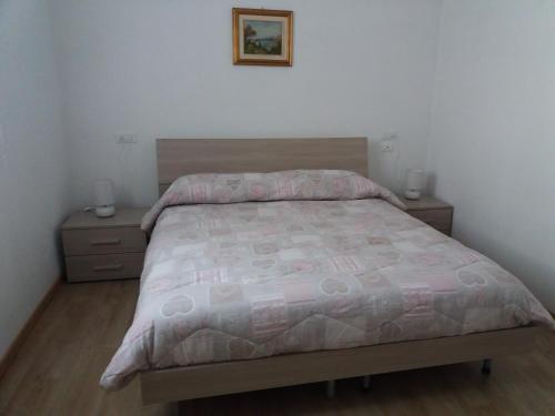 a bedroom with a bed and two night stands at Appartamento Garda Dolomiti crocevia tra laghi e montagne in Comano Terme