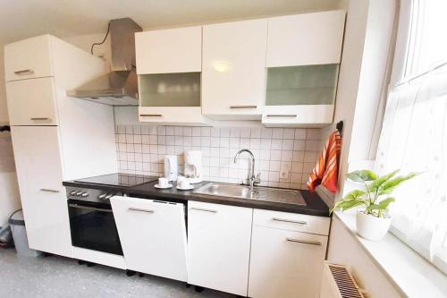 a kitchen with white cabinets and a sink at Ferienwohnung in Lennestadt in Lennestadt