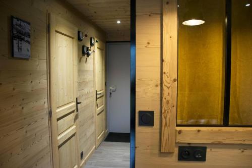 un pasillo con paredes de madera y una puerta en Appartement 3 étoiles - au pied des pistes, en Valmeinier