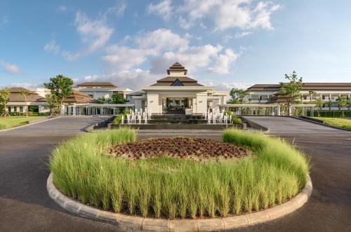 a building with a garden in front of it at Chainarai Riverside - SHA Plus Certified in Chiang Rai