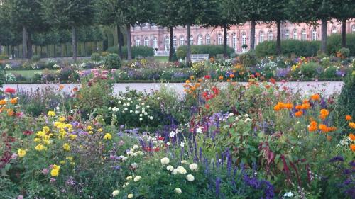 a garden full of flowers in front of a building at Komfortables 3-Zimmer Apartment in Schwetzingen zwischen Mannheim und Heidelberg in Schwetzingen