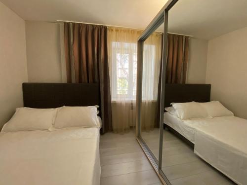 um quarto com 2 camas e um espelho em 3-bedroom apartment Most City area em Dnipro