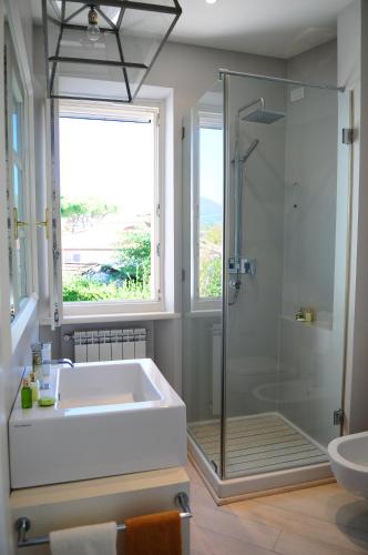 bagno con vasca, lavandino e finestra di Olive Beach Forte dei Marmi a Forte dei Marmi