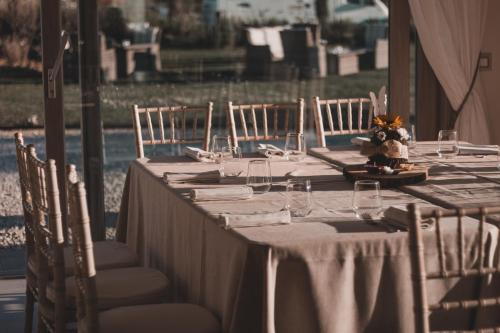 a long table with white table cloth and chairs at Fattoria L'Olmetto in Pisa