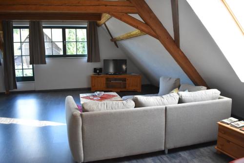 sala de estar con sofá blanco y algunas ventanas en Ferienwohnung Sternkopf en Breitenbrunn