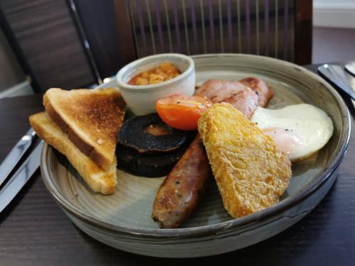 a plate of breakfast food with eggs sausage and toast at Aston Hall Hotel, BW Signature Collection in Sheffield