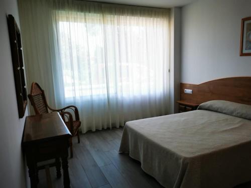 sypialnia z łóżkiem i dużym oknem w obiekcie Loft Pedras Negras w mieście San Vicente do Mar