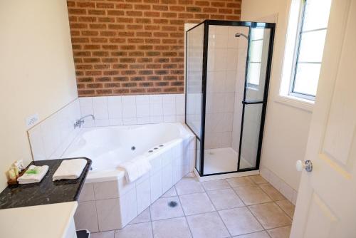 a bathroom with a tub and a glass shower at Motel Views Yackandandah in Yackandandah