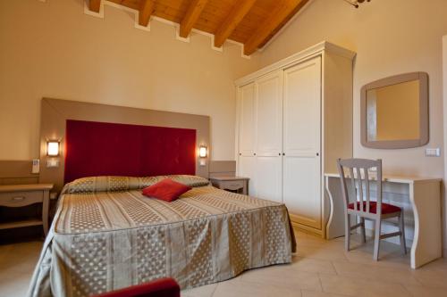 1 dormitorio con cama, escritorio y silla en Garda Hill Agriturismo, en Soiano del Lago